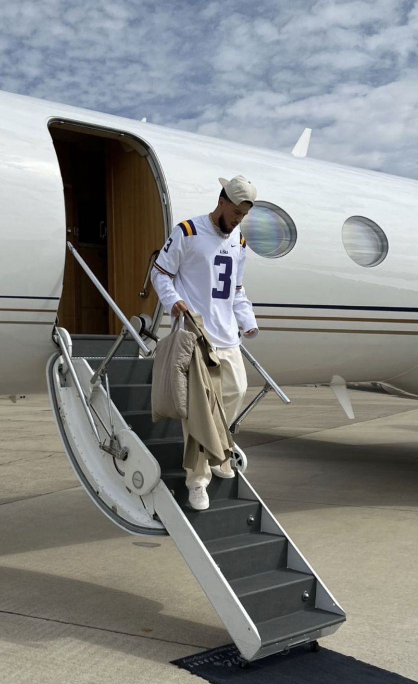 Daniel R. shot in front of a private jet at night